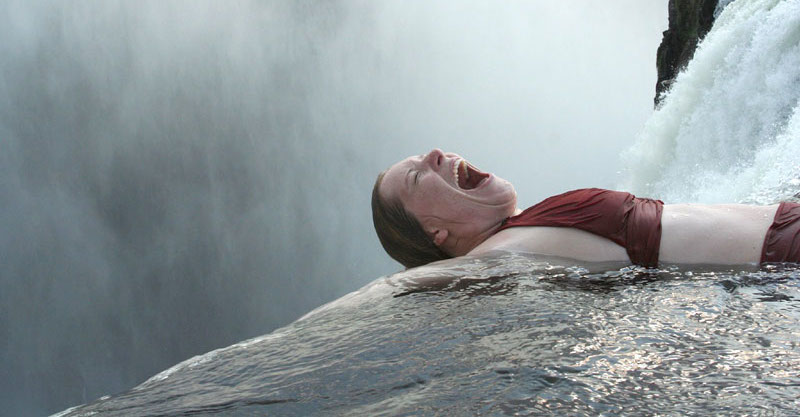 woman screaming in water, about to go over waterfall